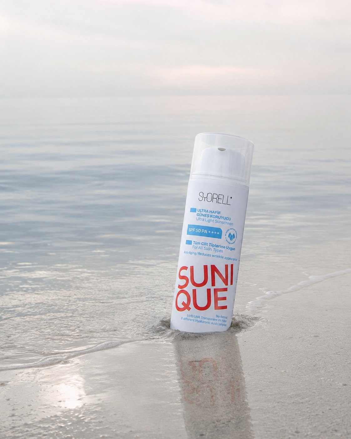 Sunique Anti-Aging Ultra Light SPF 50 sunscreen bottle in calm shallow water at misty morning