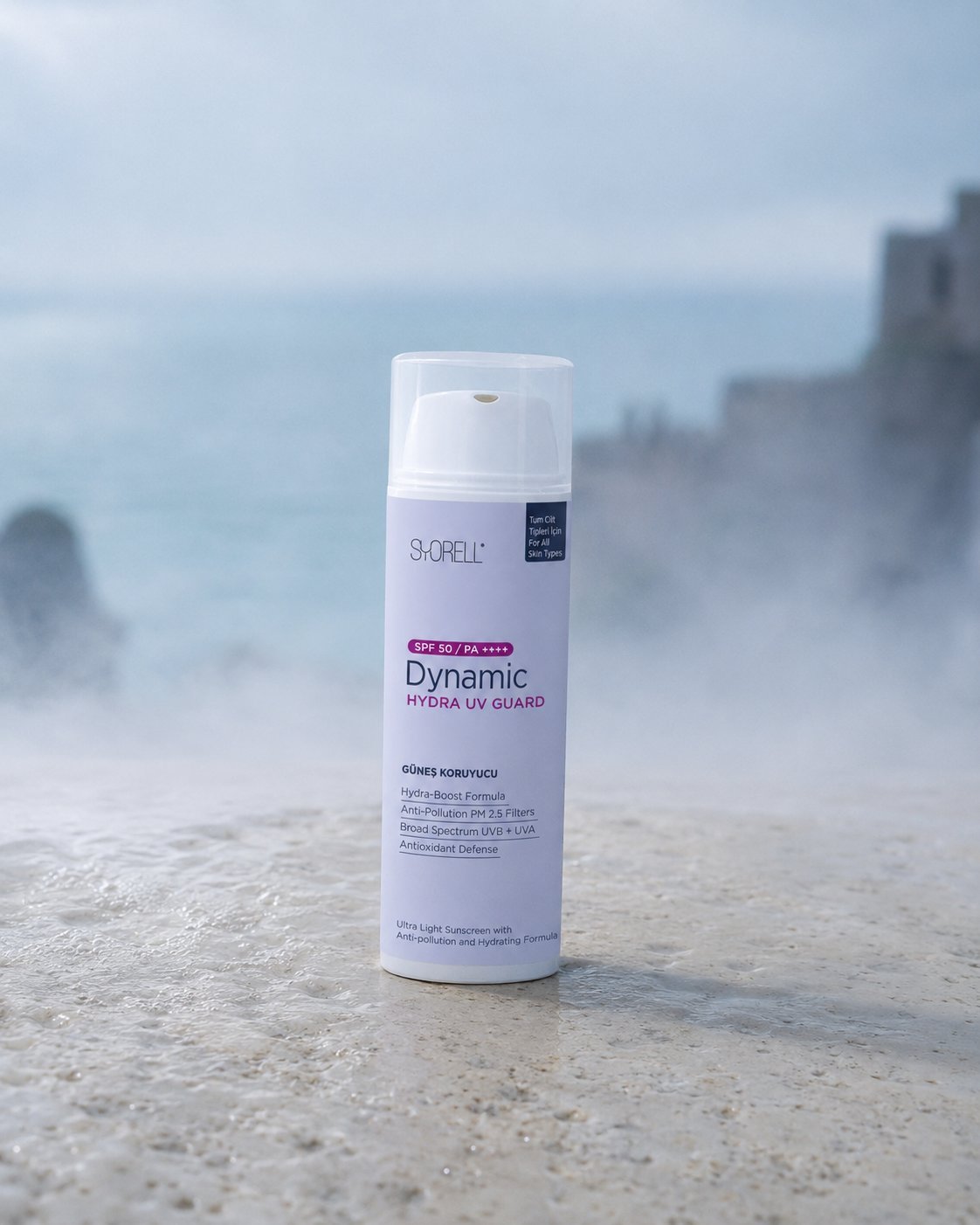 Dynamic Hydra UV Guard SPF 50 sunscreen on pale stone surface in morning mist with blurred Mediterranean coast